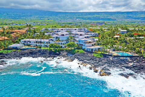Royal Sea Cliff Kona by Outrigger resort buildings set in the hills next to a beach in Hawaii