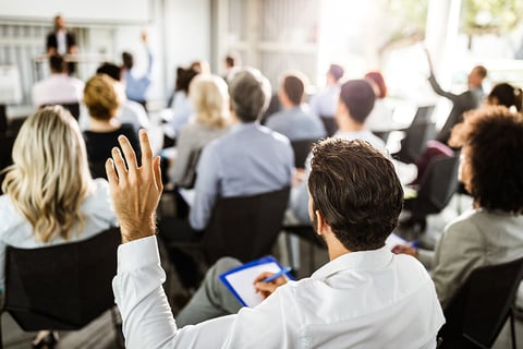 Conference Stock Photo A man raises his hand at a conference.