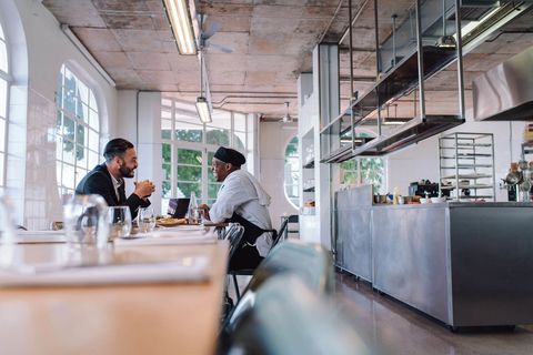 Restaurant owner and chef talking and laughing Restaurant manger and chef talking and laughing