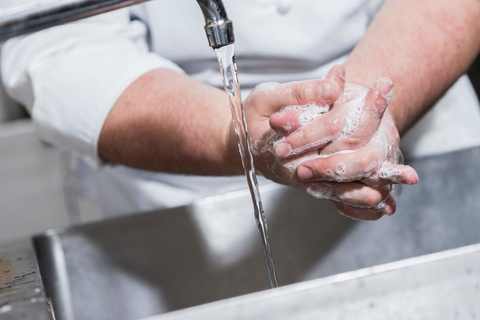 Restaurant kitchen employer washes hands Restaurant kitchen employer washing hands