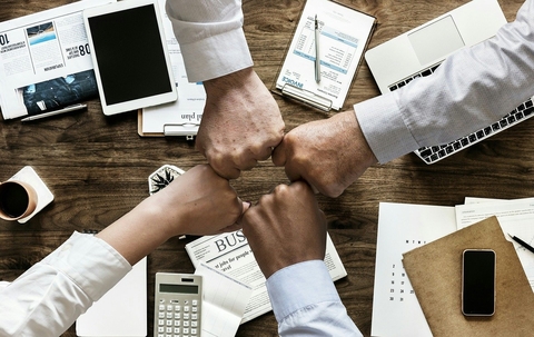 teamwork fist bump over work table