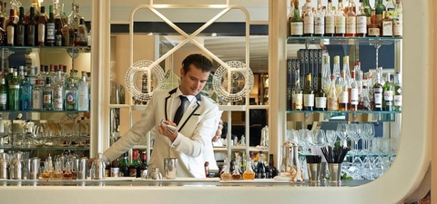 American Bar at the Savoy Hotel, London a man mixing drinks at a bar