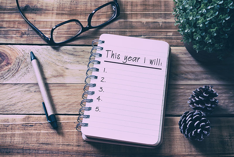 New Year's Resolutions Getty New Year Resolutions List on Notepad on Top of Wood Desk