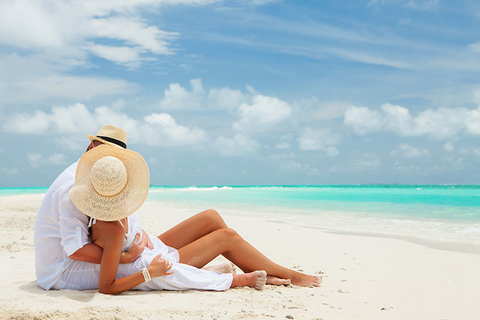 Beach Couple Romance Travel Getty Revised A couple lounging on the beach