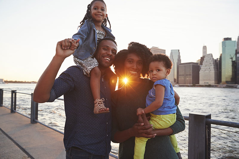 Millennial Family Getty Young family with daughters standing on quayside