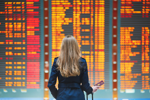 woman at airport looking at information board woman at airport looking at information board