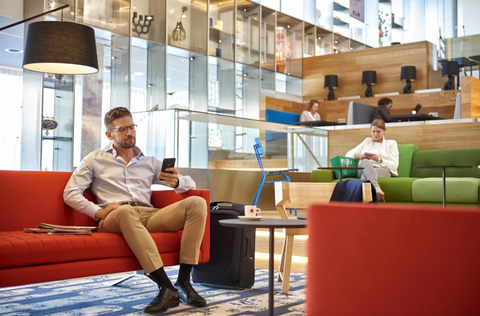 KLM non Schengen Crown Lounge Travelers sit on a colorful sitting area