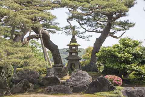 Kenrouken Garden in Kanazawa Abercrombie & Kent A stone memorial sits between two trees in a garden