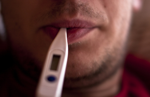 Sick man with thermometer in his mouth