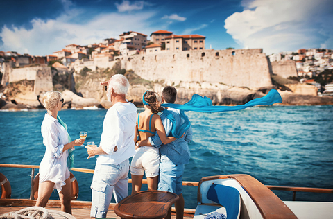 old and young couple on a sailboat looking at coastline old and young couple on a sailboat looking at coastline