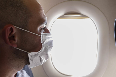 Man on airplane with mask Man on airplane with mask