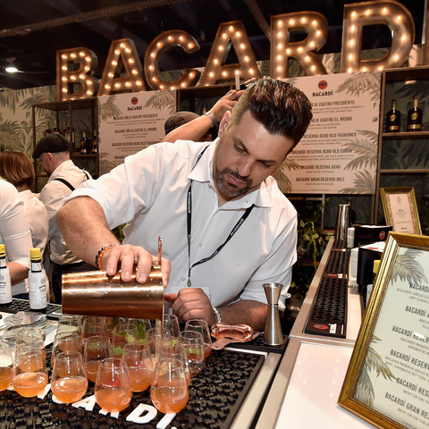 Bartender pouring cocktails at the Bacardi booth at the 2018 Nightclub & Bar Show Bartender pouring cocktails at the Bacardi booth