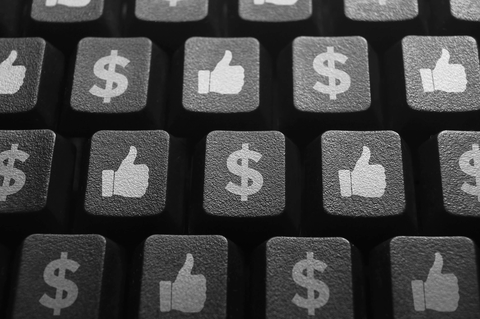 Making money with social media Dollars signs and like icons on a keyboard