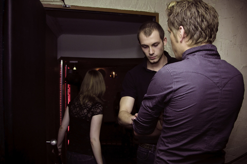 Bar or nightclub security checking IDs Bouncer checking IDs at a bar or nightclub