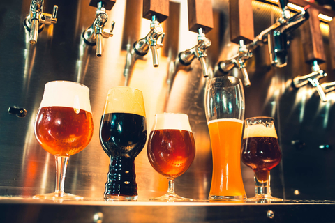 Several types of beer underneath taps Different beers and beer taps