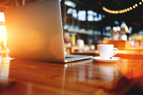 Open laptop on a wooden table in a restaurant or cafe Open laptop on a wooden table in a bar or coffee shop