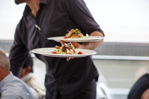 Server wearing black delivering food Server carrying plates and delivering food