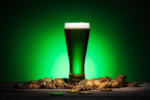 Green pint of beer and gold coins for St. Patrick's Day Green beer surrounded by gold coins on St. Patrick's Day
