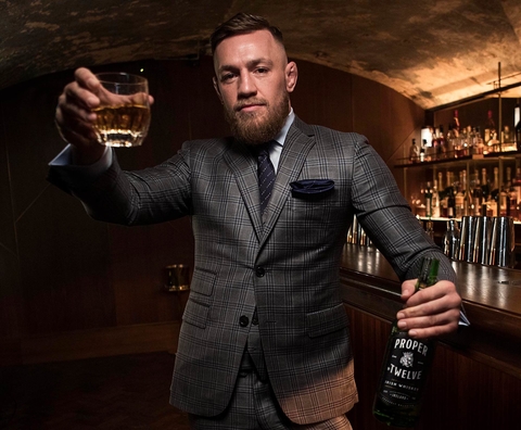 Conor McGregor holding Proper No. Twelve inside a bar