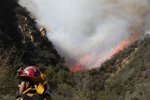 California Wildfires Newscred Editorial Travel Group Only A firefighter monitors a wildfire burning along a hillside in Malibu, CA.