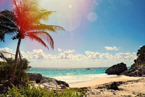 Cancun Beach Getty Sun shining down on a beach between cliffs in Cancun Mexico