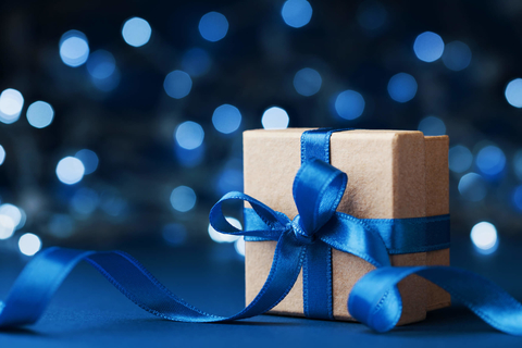Gift box wrapped with blue ribbon against blue background Gift box wrapped with blue ribbon