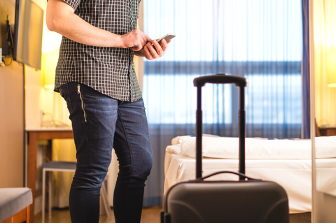 Man on mobile phone in hotel room How smart rooms can transform hotel brands
