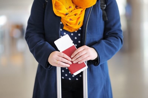 Passport Visa Immigration Immigrant Travel airport medical tourism (Getty/SbytovaMN) A woman holding a passport and plane ticket.