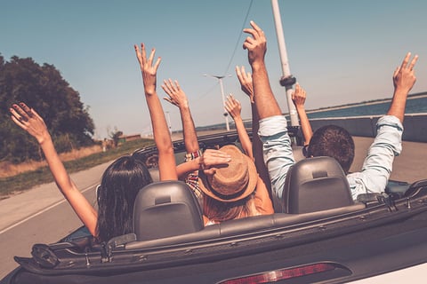 Road Trip Getty Rear view of young happy people enjoying road trip in their convertible and raising their arms up