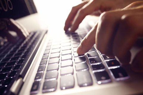 Hands typing on a laptop keyboard Hands typing on a laptop