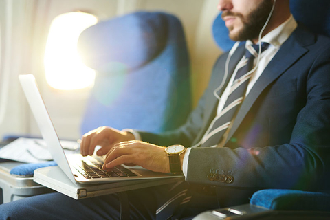 man on laptop on airplane man on laptop on airplane