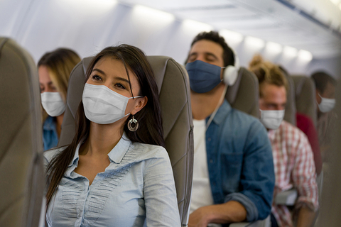 People on an airplane wearing masks People on an airplane wearing masks