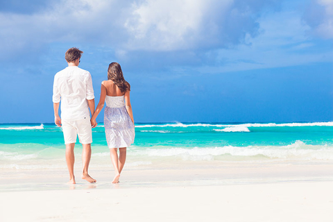 Honeymoon Getty young happy couple in white at tropical beach. honeymoon