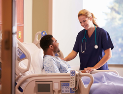Doctor patient hospital Female doctor talking to male patient in hospital bed