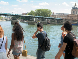U by Uniworld Editorial Young travelers walk along the Seine River in Paris