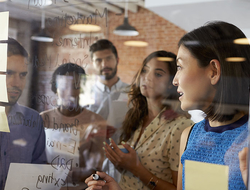 Millennials Working Credit monkeybusinessimages iStock Getty Images Plus Getty Images Businesswoman Writing Ideas On Glass Screen During Meeting