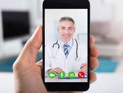 Smartphone healthcare visit Close-up of video conference with smiling male doctor on smartphone