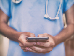 doctor using smartphone doctor in hospital hallway using smartphone