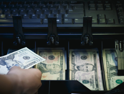 Cash register full of money Hand reaching into or pulling out of cash register