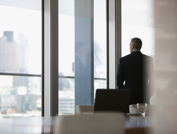 Executive c-suite (Credit: Getty/Tom Merton) Executive looking out window