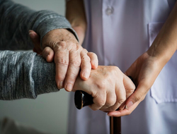 Elderly old patient geriatrics end of life care home care nurse (Getty/Rawpixel) A nurse holding the hands of an elderly patient