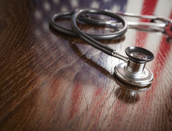 American flag with stethoscope Stethoscope on wooden table with American flag reflected on the wood