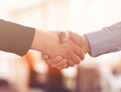 Handshake Close-up of handshake between person in suit and person in business shirt.