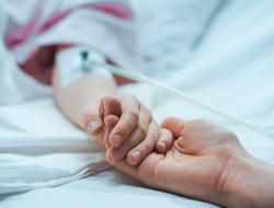 patient in hospital bed photo of child lying in the hospital bed sleeping with parent holding the child's hand, comforting