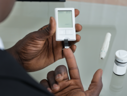 Patient measuring blood glucose Patient measuring blood glucose