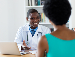 doctor consulting with patient doctor sitting at desk consulting with patient