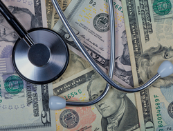 Healthcare costs Stethoscope on top of five, ten, and twenty dollar bills.