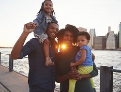Millennial Family Getty Young family with daughters standing on quayside