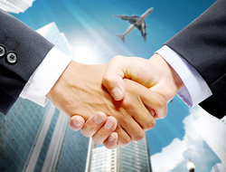 handshake with airplane in background // Photo by manfeiyang/iStock/Getty Images Plus/Getty Images handshake with airplane in background