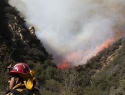 California Wildfires Newscred Editorial Travel Group Only A firefighter monitors a wildfire burning along a hillside in Malibu, CA.